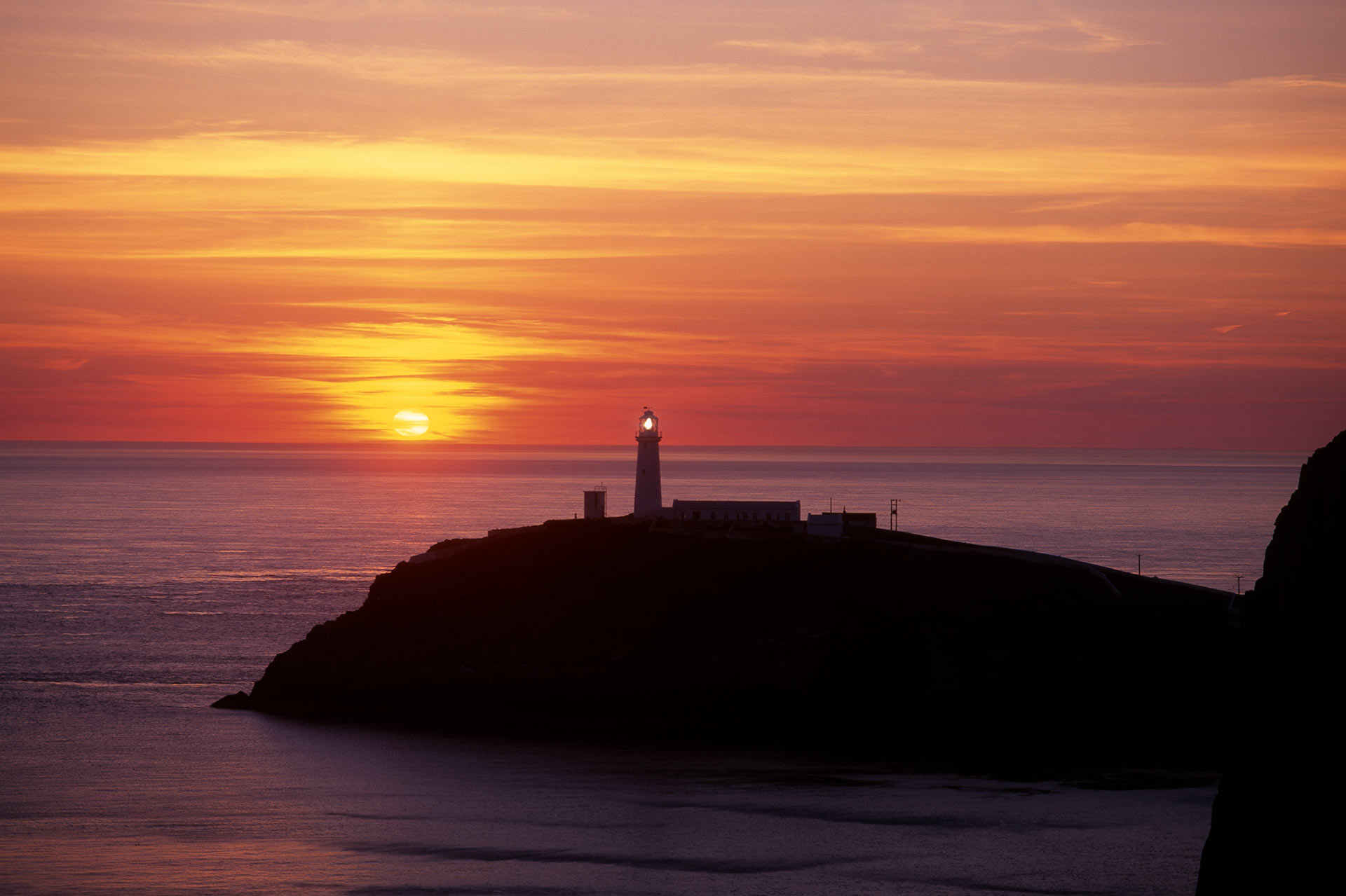 Things to do in Anglesey Image of South Stack lighthouse at sunset