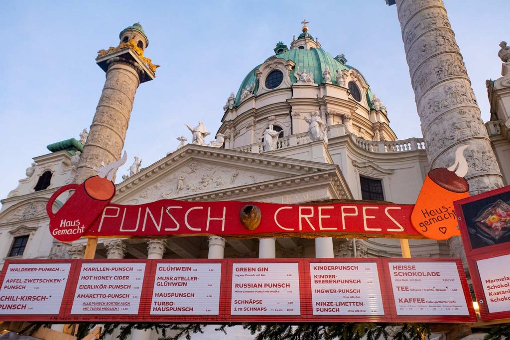 Image of Christmas market food menus below the Karlskirche Vienna