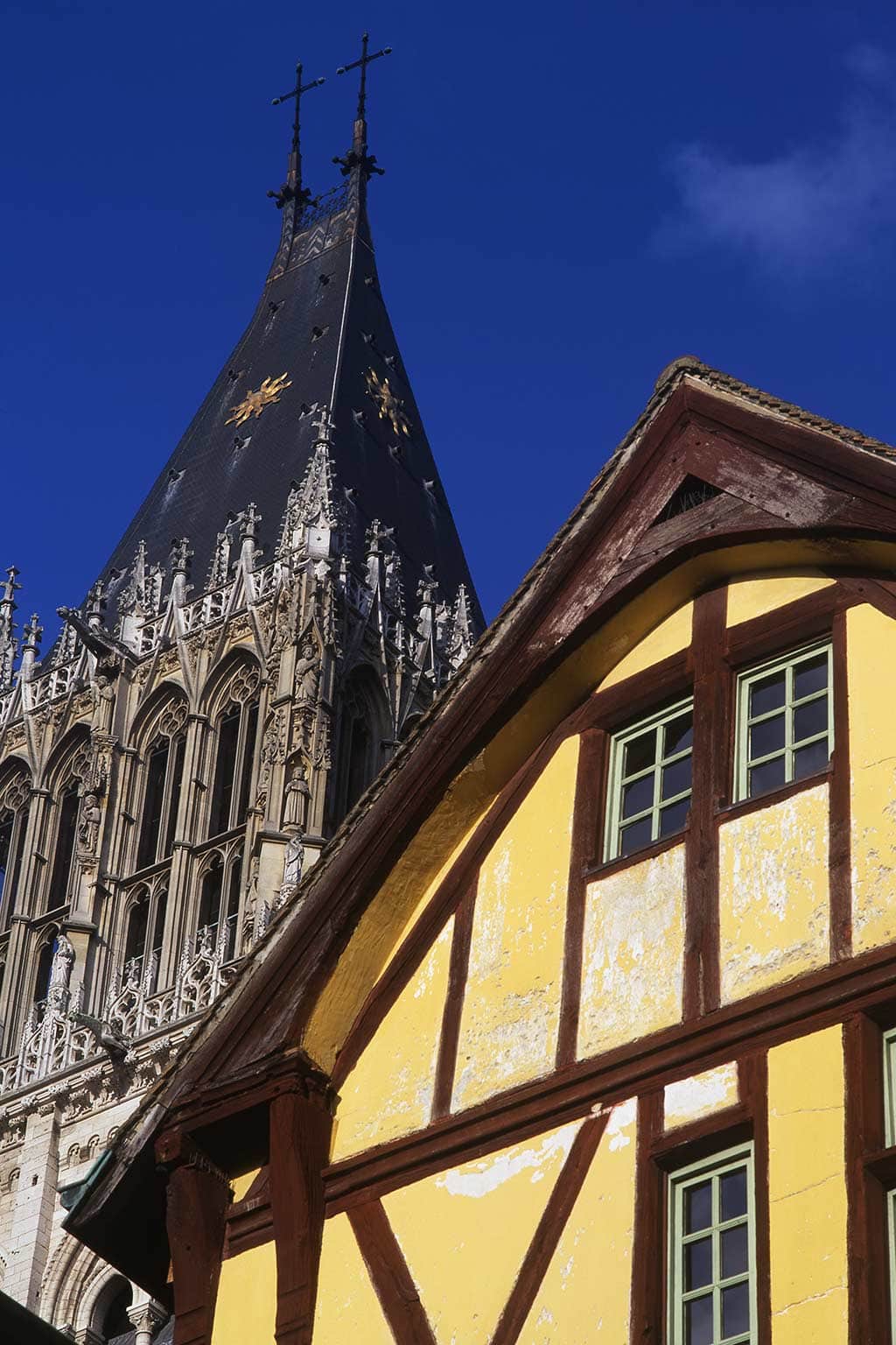Image of a medieval house and one of the towers of Rouen Cathedral Normandy France