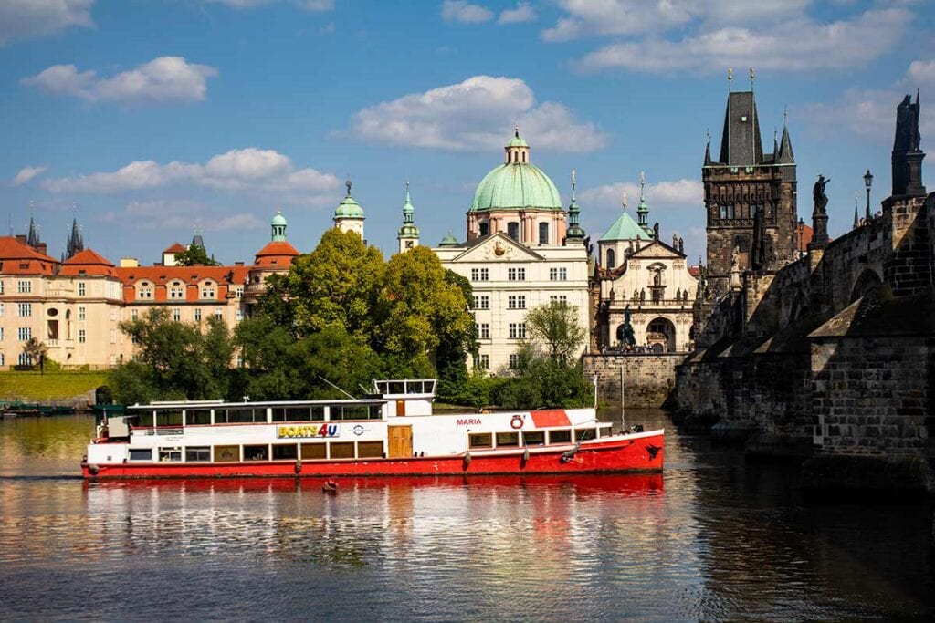 image of Vltava river cruise boat and Charles bridge prague czech republic