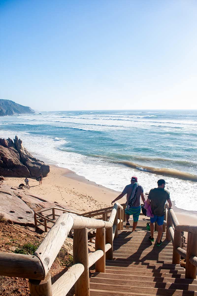 image of people walking down to amado beach portugal