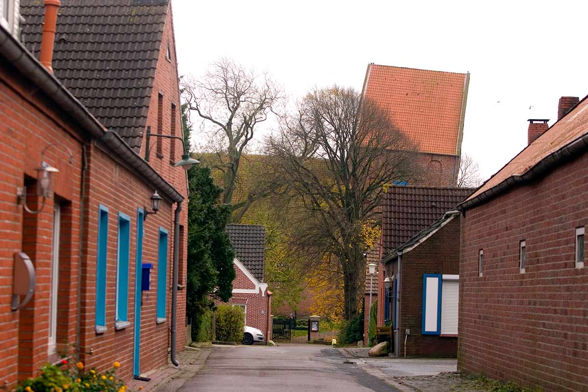 image of Suurhusen church and street of houses to the north Lower Saxony germany
