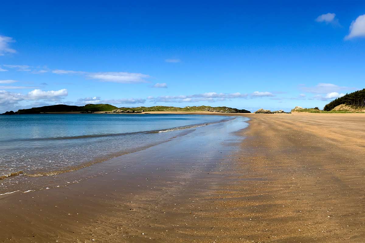 image of newborough beach looking towards llanddwyn island anglesey north Wales uk