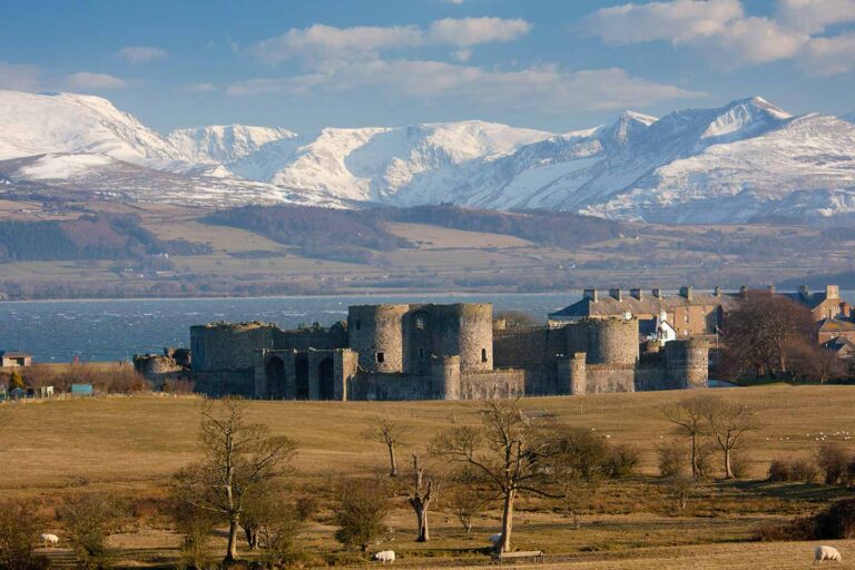 things to do in Beaumaris image of Beaumaris castle and snowdonia in winter anglesey north Wales uk