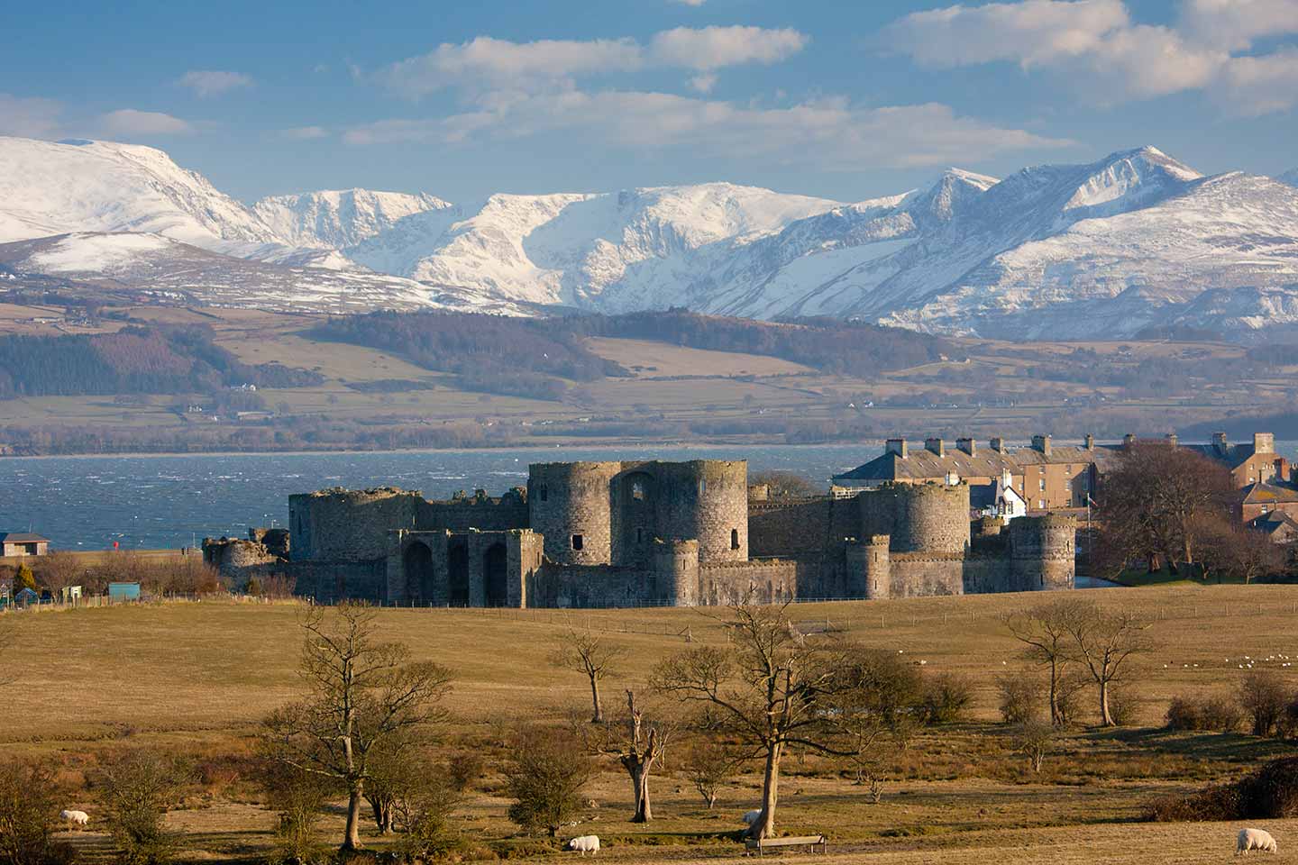things to do in Beaumaris image of Beaumaris castle and snowdonia in winter anglesey north Wales uk