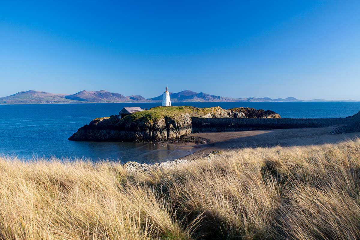 image of beach and lighthouse on llanddwyn island anglesey north Wales uk