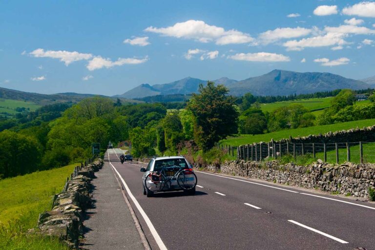 a5 road trip image of car on scenic a5 road approaching mountains of snowdonia north Wales uk