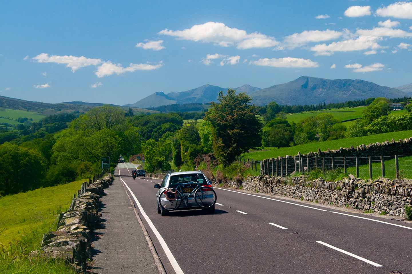a5 road trip image of car on scenic a5 road approaching mountains of snowdonia north Wales uk