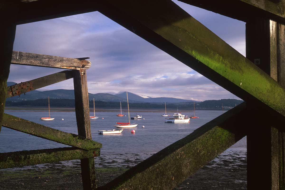image of Beaumaris pier and boats on menai strait anglesey north Wales uk