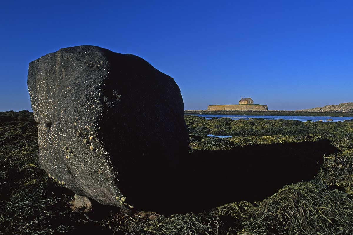 image of north Cwyfan church from beach anglesey north Wales uk