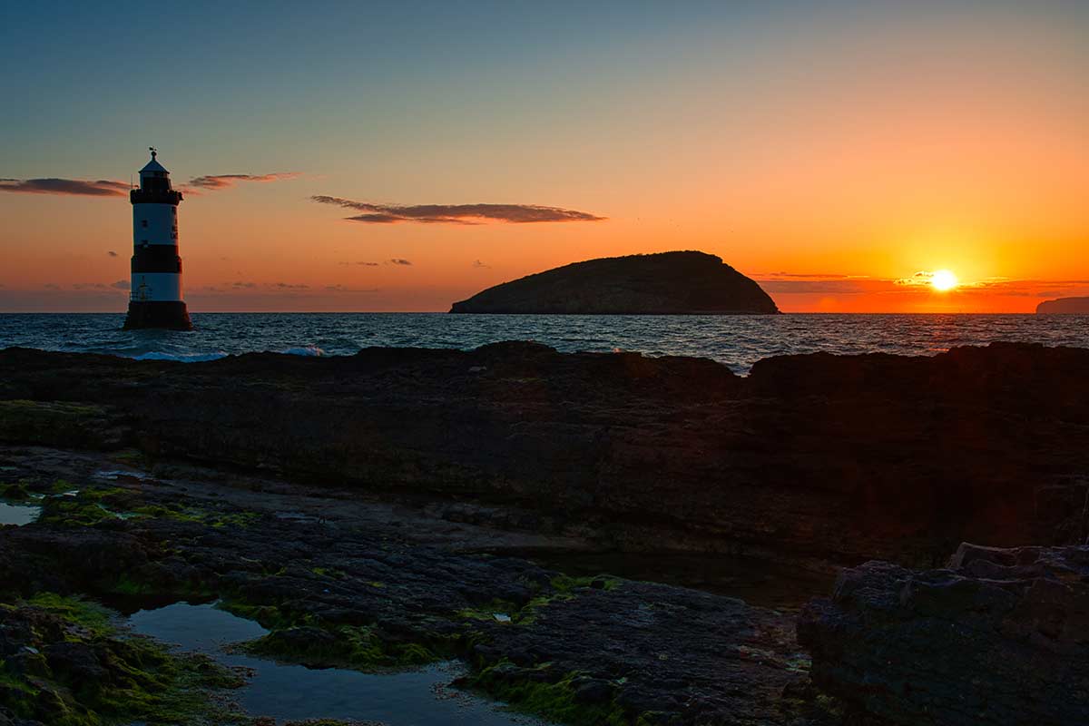image of puffin island and pennon point lighthouse at sunrise anglesey north Wales uk