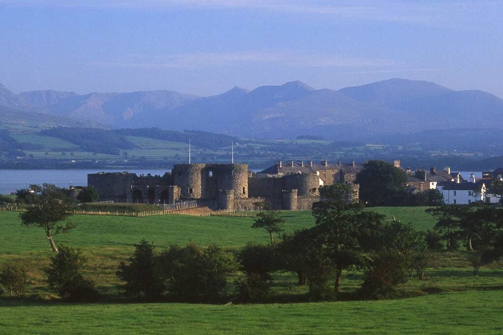 image of Beaumaris castle and mountains of snowdonia anglesey north Wales uk