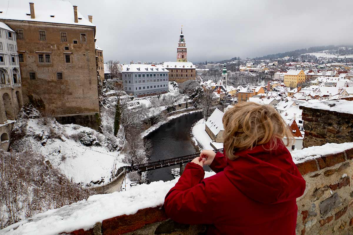 image of boy looking at cesky krumlov castle in snow czech republic