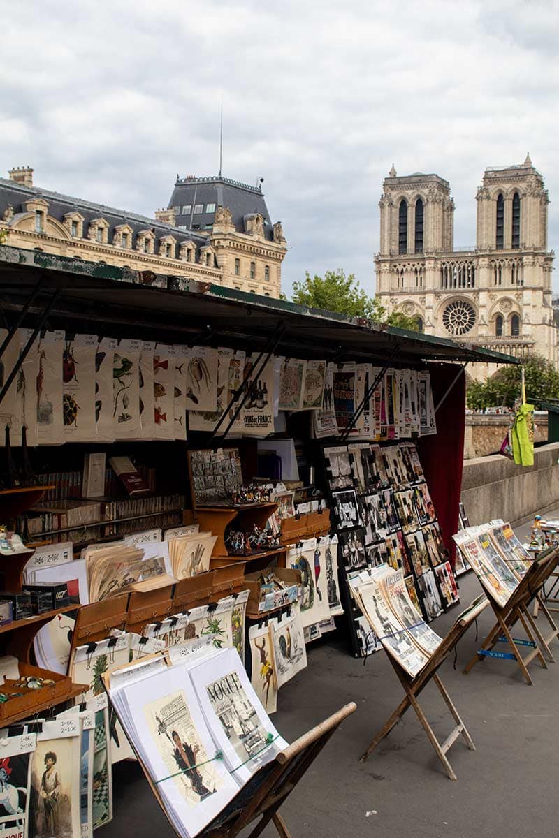 image of bouquiniste stall with Notre dame in background latin quarter Paris france