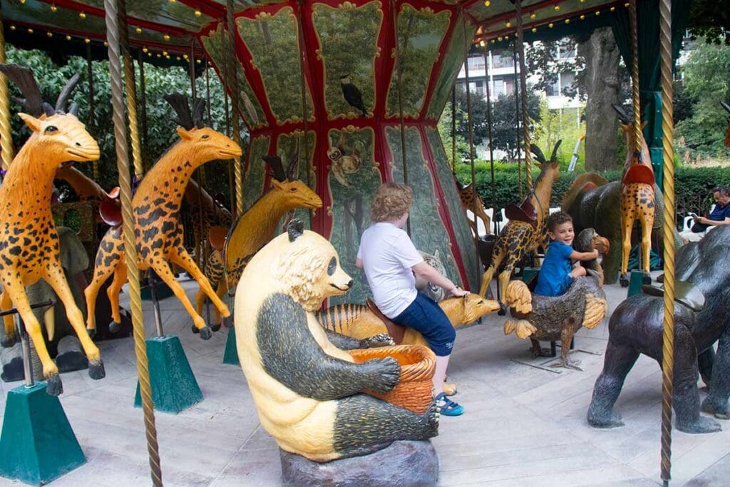 image of boy riding on dodo manege carousel latin quarter Paris france