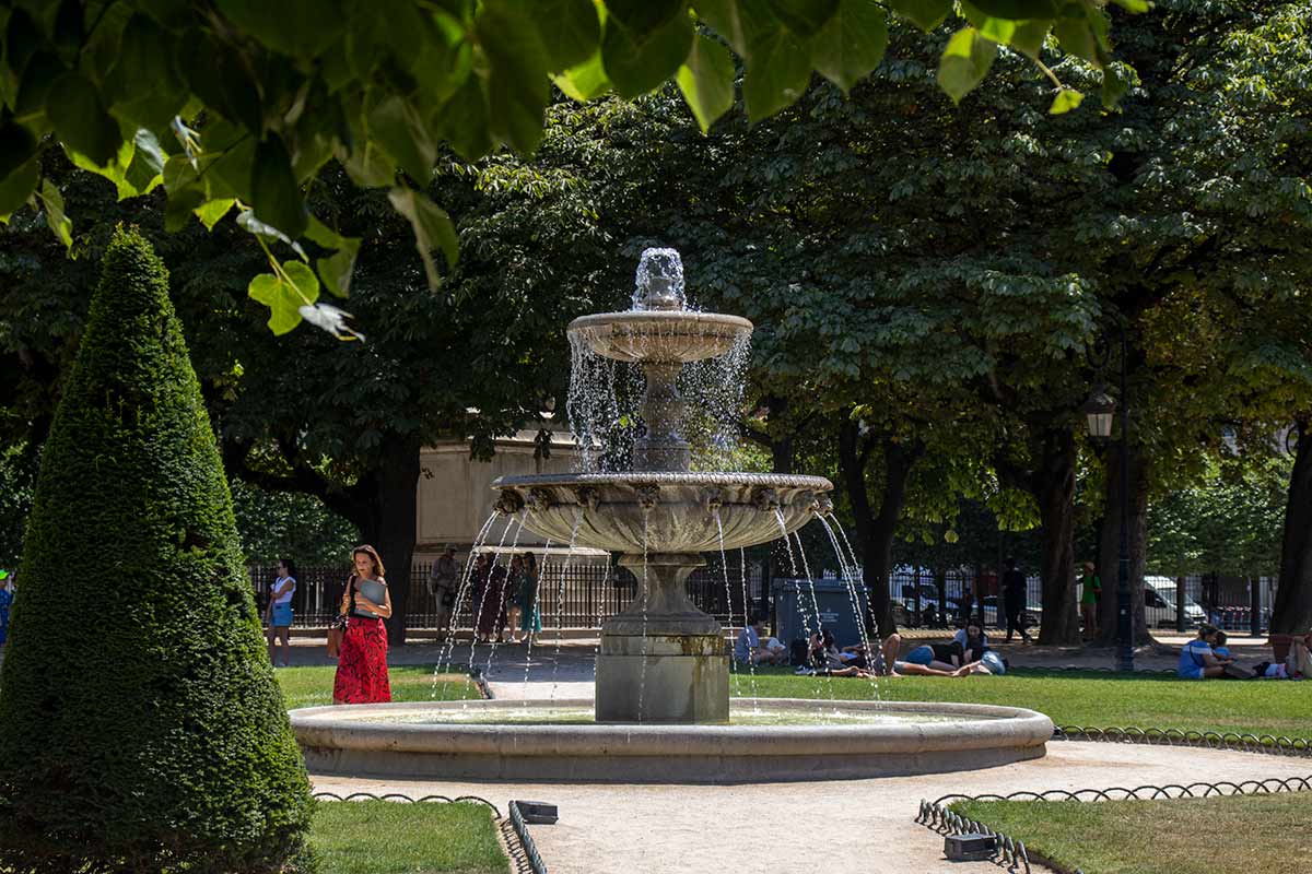 image of fountain and gardens in place des vosges Paris france