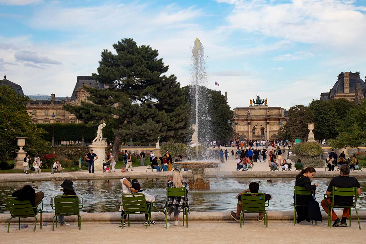image of people sitting around the grand basin pond in the Tuileries garden paris