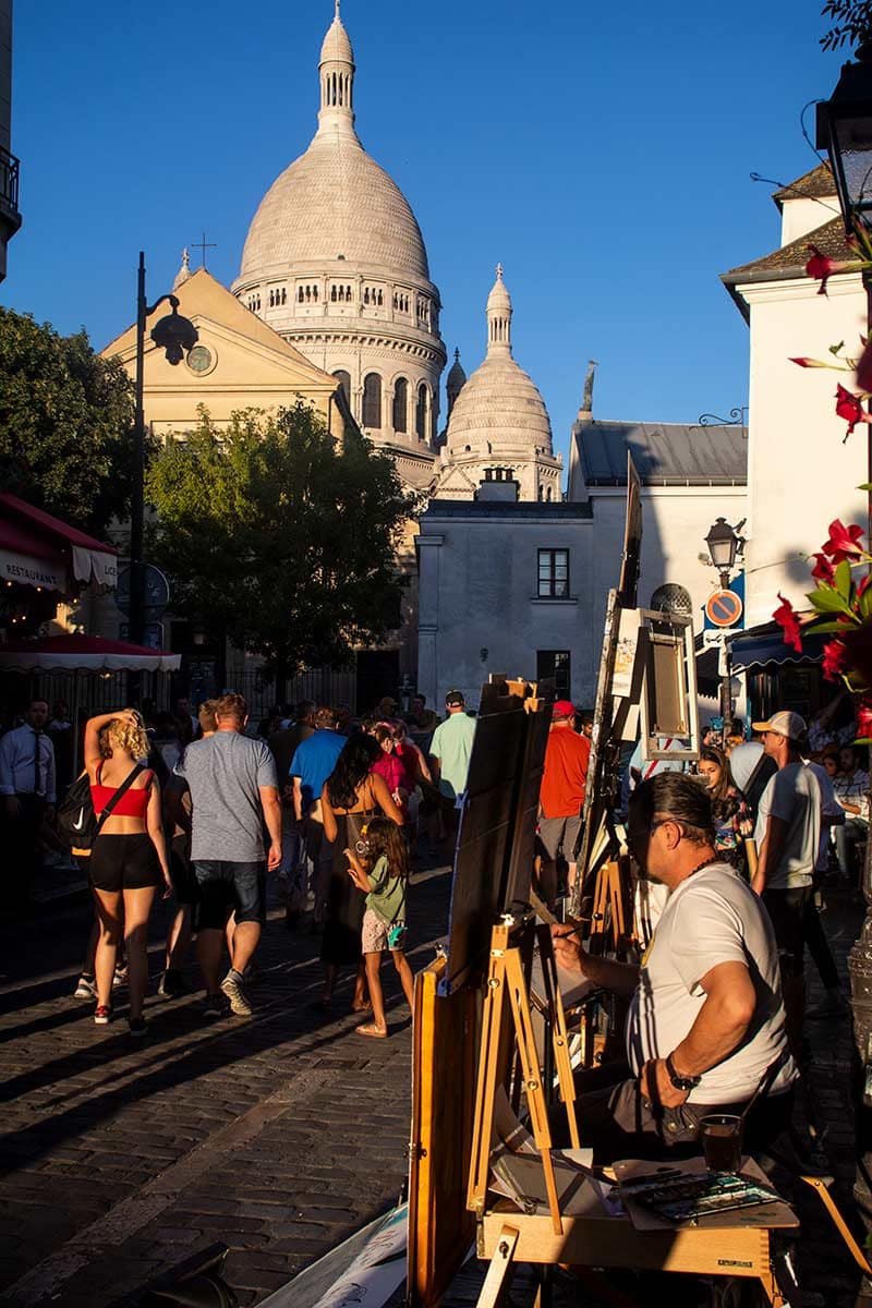 image of artist on place du tertre and sacre coeur basilica montmartre Paris france