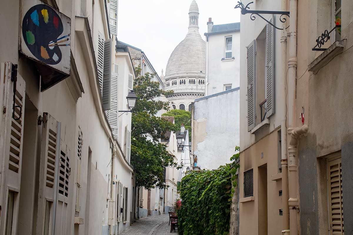 image of sacre coeur basilica seen from rue saint rustique Montmartre Paris france